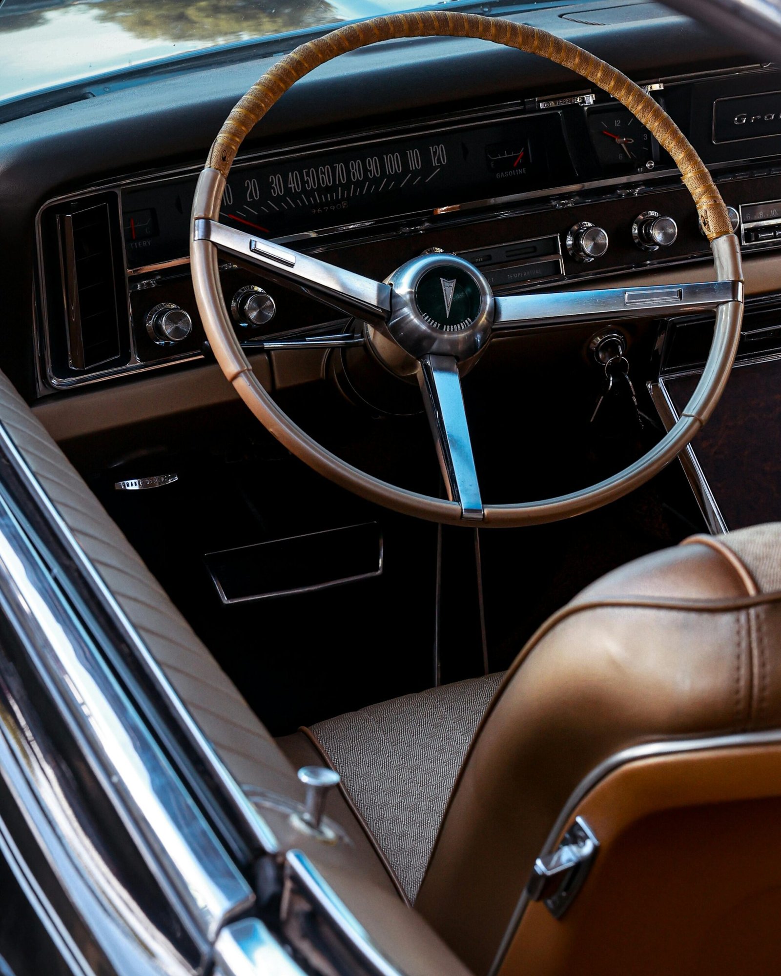 Detailed view of a classic Pontiac car steering wheel and dashboard interior.